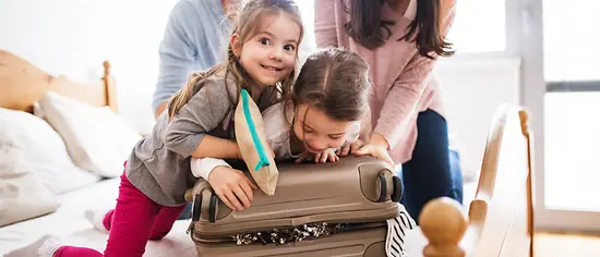 Familie beim Packen der Koffer: Packliste Urlaub